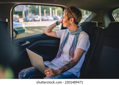 One Mature Woman Caucasian Female Sitting On The Back Seat Of The Car Working On Laptop Computer In Summer Day With Short Gray Hair Modern Manager Or Business Owner On Road Wearing Casual Copy Space