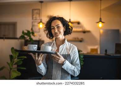 Photo of One mature woman caucasian waitress at cafe or restaurant carry tray with coffee female entrepreneur at work real people copy space small business concept