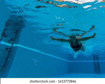 One Mature Woman Or Senior Swimming Alone In A Swimming Pool And Training To Be Healthy And Fitness - Active Female - Under Water View