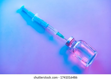 One medical glass bottle with syringe. blue background and a medical disposable syringe with a needle. Medical concept shows a medical test tube and vaccines against coronavirus. Copy place - Powered by Shutterstock