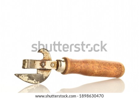 One metal can opener with a wooden handle, retro, close-up isolated on white.
