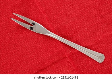 One Metal Fork On A Red Linen Napkin, Macro, Top View.