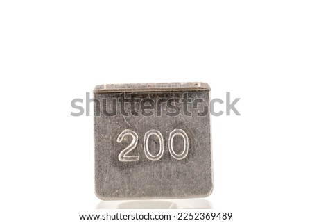 One metal weight for old jewelry scales, macro, isolated on white background.
