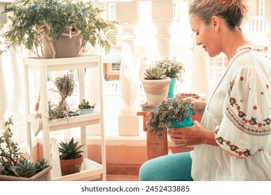 One middle age woman enjoy gardening outside in the terrace at home. Happy people love nature plants and flowers and enjoy outdoor leisure activity having relax. Serene lady in home balcony terrace - Powered by Shutterstock