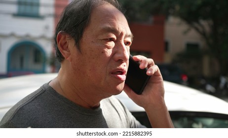 One Middle Aged Asian Man Speaking On Phone In Street. Happy Person Listening On Smartphone In Sunlight