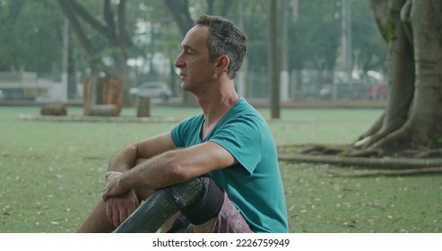 One middle aged disabled man with prosthetic leg sitting outside with sportive clothes - Powered by Shutterstock