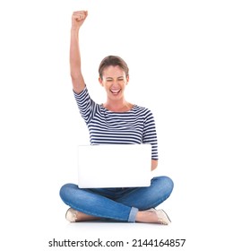 One Million Likes. Studio Shot Of A Young Woman Sitting Cross Legged On The Floor Cheering While Using A Laptop.