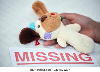 One missing child is one too many. Closeup shot of an unrecognisable woman holding a teddy bear alongside a missing person poster.