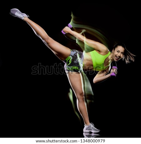 one mixed race woman exercising fitness exercises isolated on black background with lightpainting effect