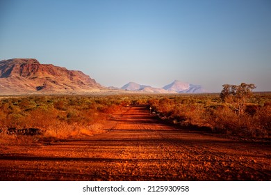 One of the most beautiful red dirt-roads in the Karijini National Park in Western Australia at sunset. - Powered by Shutterstock