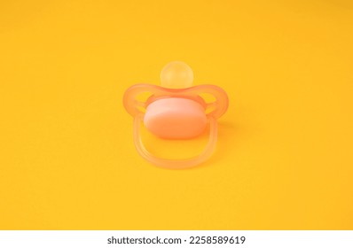 One new baby pacifier on orange background - Shutterstock ID 2258589619