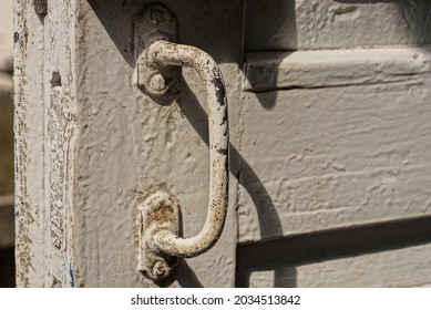 One Old Dirty Gray Iron Doorknob On White Wooden Door Planks