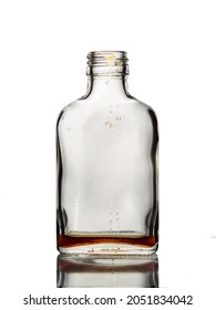One open empty glass bottle with drops of brown beverage on it