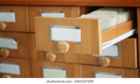 One open and many closed wooden paper filing cabinets. Archival storage of information and data. Search in old archives. Place for the inscription - mockup. Photo. Selective focus. Daylight