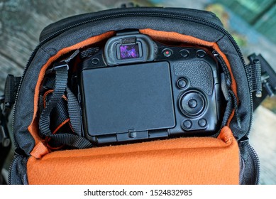 one orange bag with a black camera on a gray table
