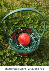 One orange Easter egg in a basket 