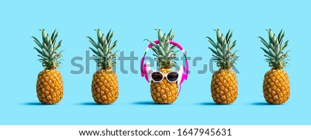 One out unique pineapple wearing headphones on a solid color background