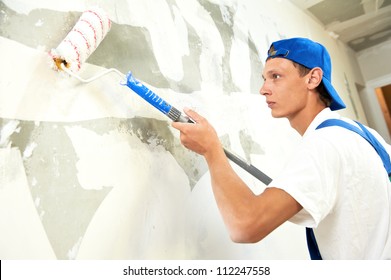 One Painter With Paint Roller Making Wall Prime Coating  At Home Repair Renovation Work