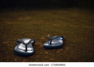 One Pair Of Home Used Blue Rubber Hawai Slippers Shoes Is Lying On The Ground And Dark Background