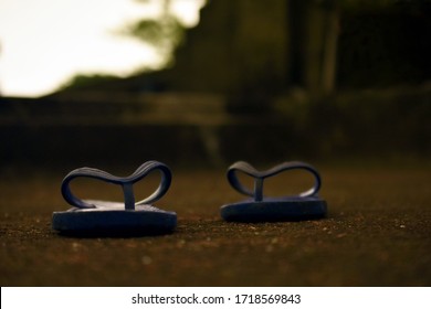 One Pair Of Home Used Blue Rubber Hawai Slippers Shoes Is Lying On The Ground And Dark Background