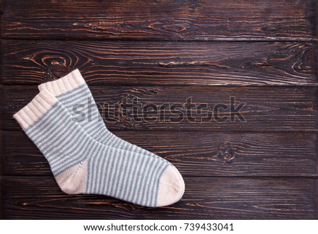 One pair white socks with light blue strip on a wooden background