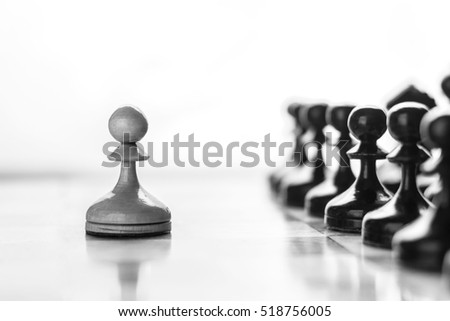 One pawn staying against full set of black chess pieces