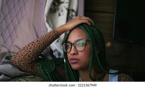 One Pensive Black Girl Sitting On Couch Looking Outside Window. A Thoughtful African American Young Woman Thinking About Life