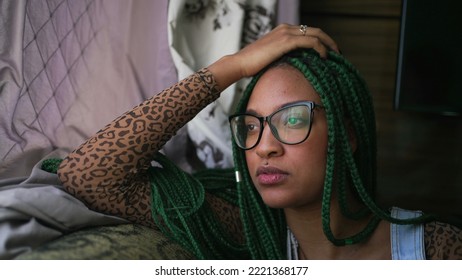 One Pensive Black Girl Sitting On Couch Looking Outside Window. A Thoughtful African American Young Woman Thinking About Life