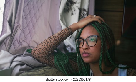 One Pensive Black Girl Sitting On Couch Looking Outside Window. A Thoughtful African American Young Woman Thinking About Life