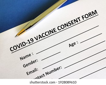 One Person Is Answering Question About Vaccines. The Person Is Filling Up Vaccine Consent Form.