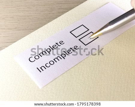 One person is answering question on a piece of paper. The person is thinking to be complete or incomplete.