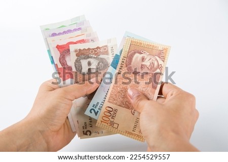 one person counts banknotes. colombian pesos.