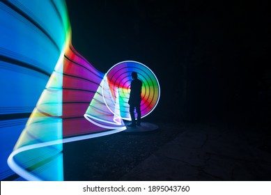 One Person Standing Against Beautiful Rainbow Circle Light Painting As The Backdrop