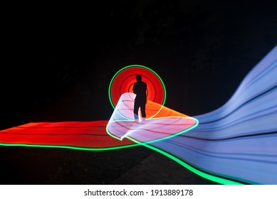 One Person Standing Against Beautiful Red And White Circle Light Painting As The Backdrop