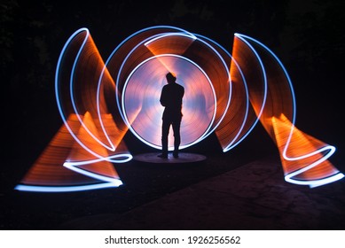 One Person Standing Against Beautiful White And Red Circle Light Painting As The Backdrop