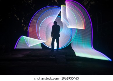 One Person Standing Against Beautiful Rainbow Circle Light Painting As The Backdrop