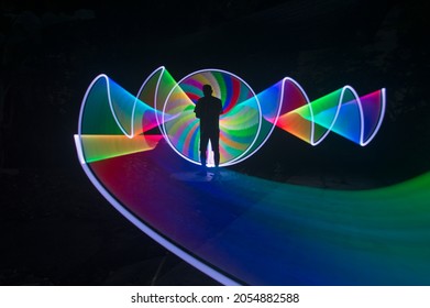 One Person Standing Against Beautiful Rainbow Circle Light Painting As The Backdrop