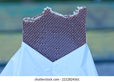 One Piece Of A Large Brown Chocolate Bar In A White Package On A Colored Background