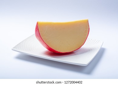 One Piece Of Traditional Dutch Red Ball Edam Cheese Close Up On White Background