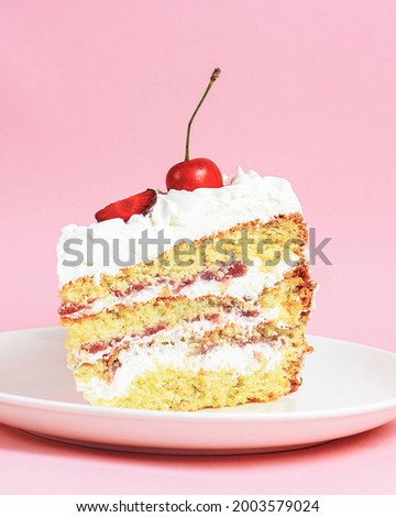 One piece of vanilla cherry cake on a white plate over pastel pink background. Delicious sweet dessert close up. Sponge cake with cream and fresh fruit on top.