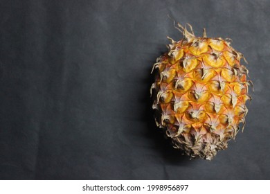 one pineapple fruit in close view and black background empty space