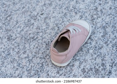 One Pink Baby Shoe On A Marble Background. Simply Lost By Someone Or Suspected Of Child Abuse Or Kidnapping