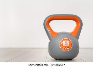 One Plastic Kettlebell Weight 8 Kg Gray And Orange Training Equipment On The Floor Copy Space