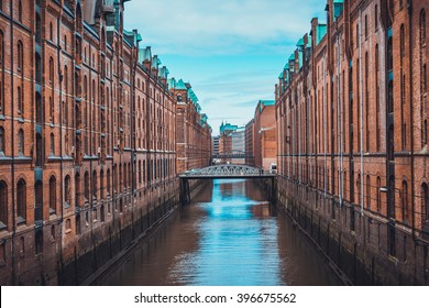One point perspective view on canal and bridges between two long rows of old brick buildings