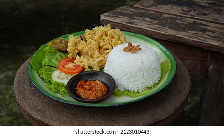 one portion of javanese fried chicken "ayam kremes" the chicken crunchy with rice and sambal.