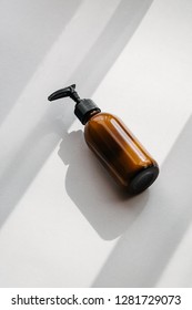 One pump dispenser glass brown bottle for cosmetics, overhead. Direct light. Beauty blogging, salon treatment, minimalism concept