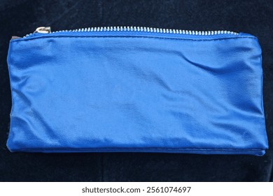 one rectangular blue leather purse bag lies on the black table - Powered by Shutterstock