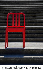 One Red Chair Profiled In Front Of Cement Steps