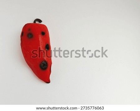 One red pepper is rotten, half-decomposed, covered with mold on a white background. Tainted, unhealthy sweet red peppers. The concept of expired food, poisoning, infection. Food waste. Part of series.