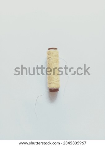 One roll peach sewing thread on white background
